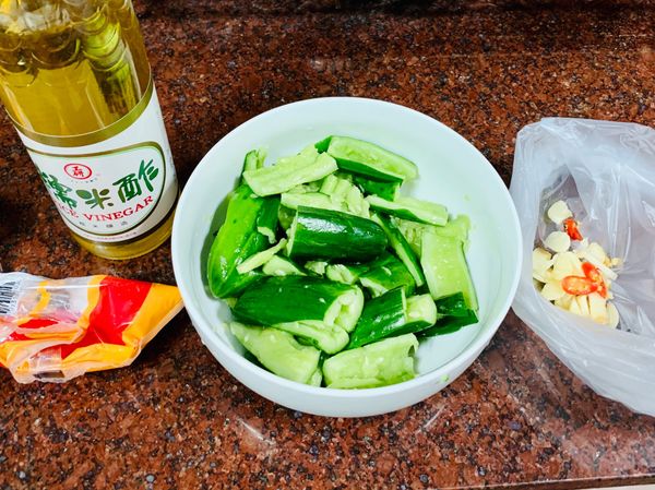 小黃瓜應該已經有出水，將水倒掉後，加入蒜頭、辣椒、糖、白醋和香油，攪拌均勻後，即可上桌

《喜歡酸一點，可以再多加一些白醋 》

《用塑膠袋可以更方便拌勻哦》

《糖只要不是大顆粒狀，容易溶解的都可以》