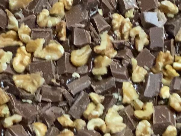 麵糊倒入鋪有烤盤紙的烤盤，最後灑上牛奶巧克力塊與核桃