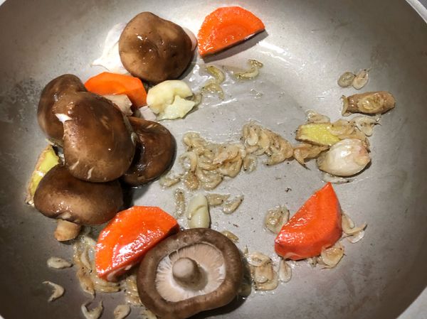 再放入香菇、蝦米跟紅蘿蔔一起拌炒出香氣。