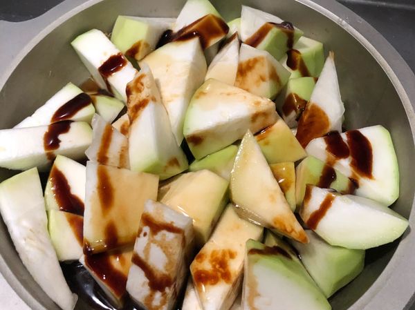 放入瓠瓜一起拌炒後，加入醬油、醬油膏跟胡椒粉，並加入水直至淹過瓠瓜，蓋上鍋蓋，小火燜煮。