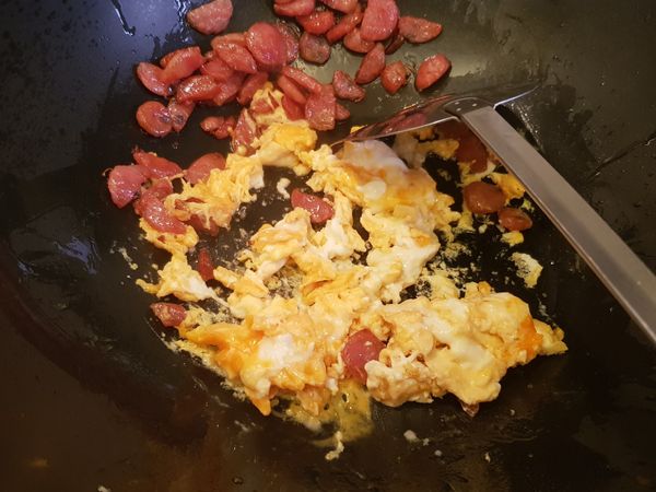 若有點結鍋可加點油輕推結鍋的蛋液，將香腸和蛋炒出香氣後，接著都以中火處理，下入菜類再拌炒把菜的甜香炒出來，過程中菜就會出點水，剛好將所有料香氣更融合，
接著撒入白胡椒粉，醬油嗆香，菜的部分炒至9分熟時，就可以下入白飯，若發現鍋內的水份不夠可以加少少少許的水，飯加入後就要關中小火了，記住👉不斷翻炒。
