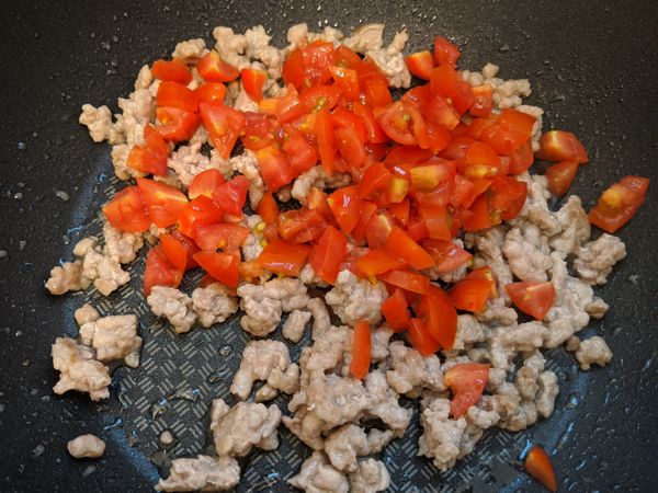 加入番茄丁，翻炒5分鐘，茄紅素出來後加入水燉煮5分鐘，讓絞肉和番茄的味道混合在一起。

📌這裡水不用一次加太多，可以到步驟5在調整最後水量。