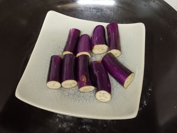 茄子置於碟中，放入蒸鍋蒸8分鐘後取出，倒走蒸水。