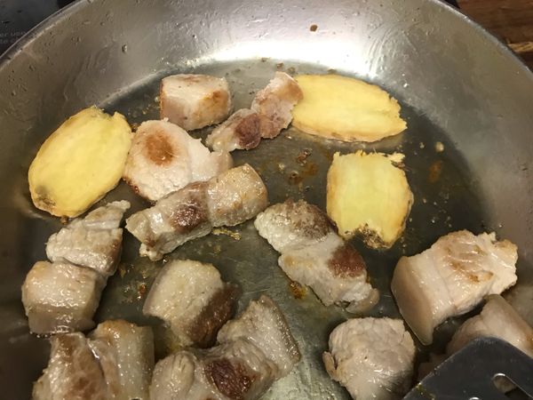 豬肉切塊，先滾水燙過兩三分鐘，然後快速沖一下冷水，沖掉血水。
加薑片，鍋裡加一點油，煎至肉有點焦黃。