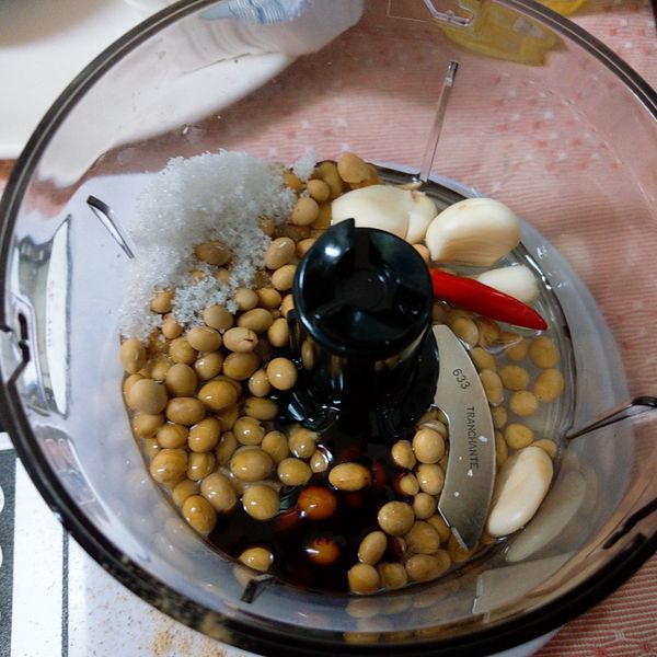 把烘烤過的黃豆+蒜頭+紅辣椒+薑+醬油+糖+鹽+砂啦油+白胡椒粉+健康油一起放入調裡盒中用均質機將所有材料攪碎拌勻備用.