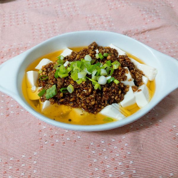 將炸酥的豆酥淋在豆腐上並灑上蔥花即完成這道豆酥豆腐.