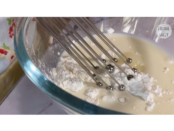 首先，我們來製作麻糬餡。
先將糯米粉、玉米粉、細砂糖以及牛奶倒入一個碗裡攪拌均勻。
放進微波爐裡微波1分鐘，取出後稍微攪拌一下，再放回去微波爐微波1分鐘。