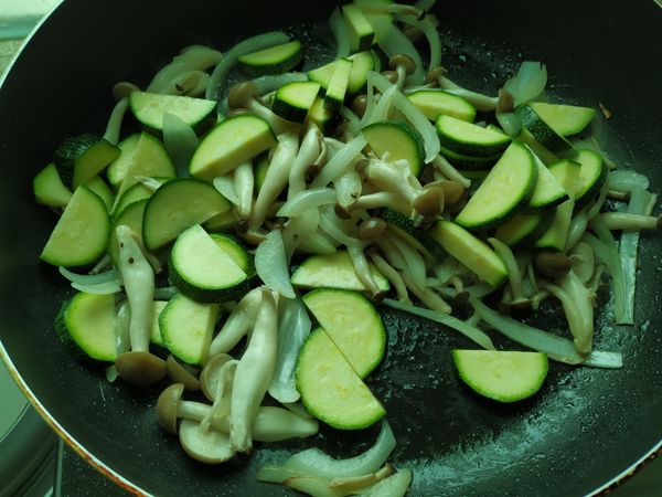 拌炒幾下後就可以加入櫛瓜，然後倒入半碗水，蓋上鍋蓋悶一下