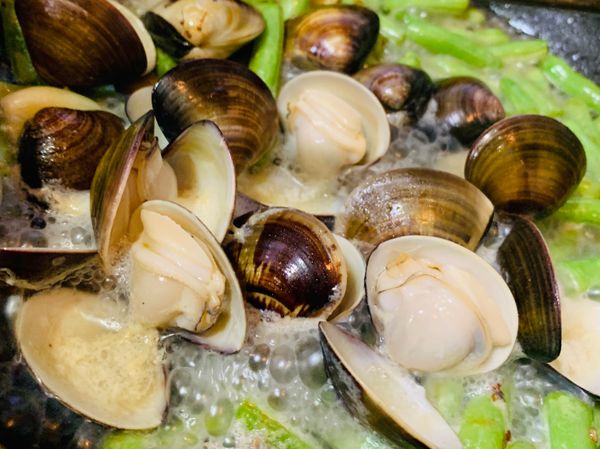 熱鍋，加入些許油，轉中火倒入四季豆翻炒兩下加入蒜頭、薑片、鹽、黑胡椒，繼續翻炒至香味出來，加入文蛤和約一杯的水，蓋鍋蓋至文蛤全開即可關火