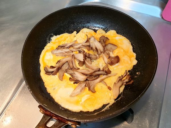 舞菇盛起備用，放些無鹽奶油融化至鍋中，將打好的蛋倒入鍋中，以筷子輕輕畫圓，之後再把舞菇放在蛋上，以蛋皮捲起稍微翻面，完成！