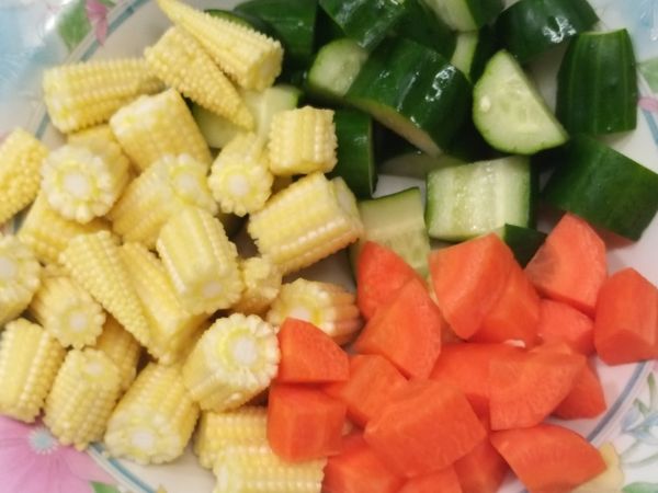 將雞胸肉、小黃瓜、紅蘿蔔、玉蜀黍切成丁狀