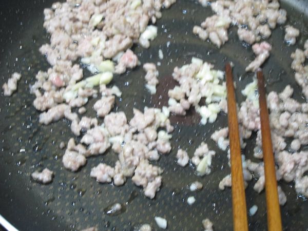 起一匙油鍋，先炒香肉末，再下蒜末爆香。