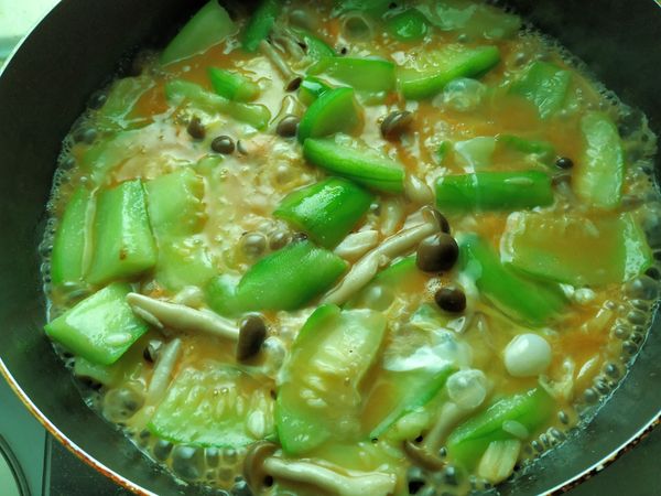 悶煮到絲瓜軟了，加鹽和白胡椒粉調好味道，淋入蛋汁,先不要拌，看到蛋汁略為凝固，滴些香油，熄火，拌一下，即可起鍋，完成