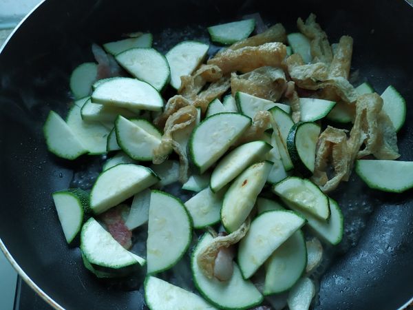 蒜香味出來，放入櫛瓜，拌炒一下讓櫛瓜沾附油脂後，加入1碗水，蓋上鍋蓋悶一下