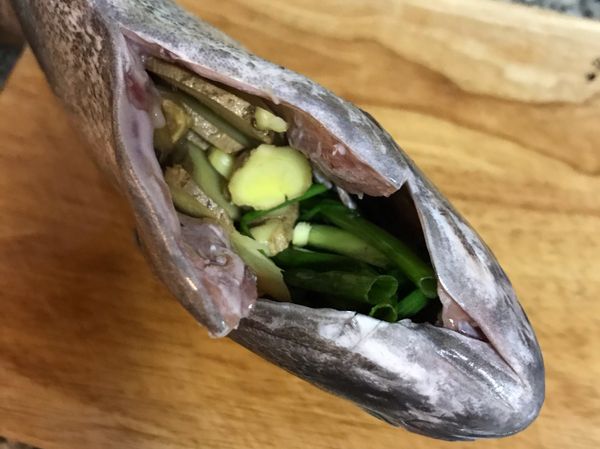 薑片和蔥段塞入魚肚中；