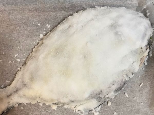 再用剩下的鹽蓋滿整隻魚；入烤箱烤25-28分鐘，（如果魚較小則20分鐘即可）；