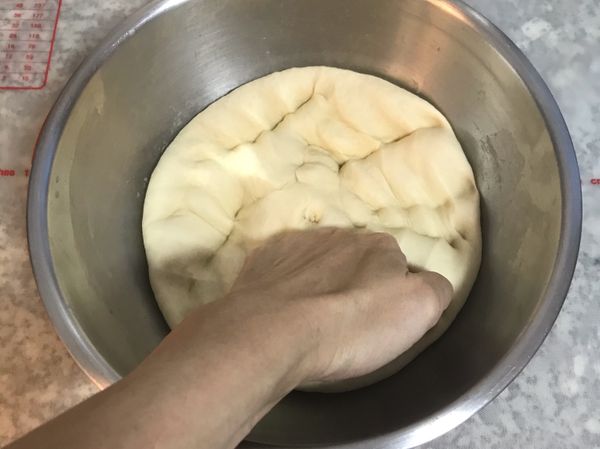 手握拳將麵糰裡的空氣排出；