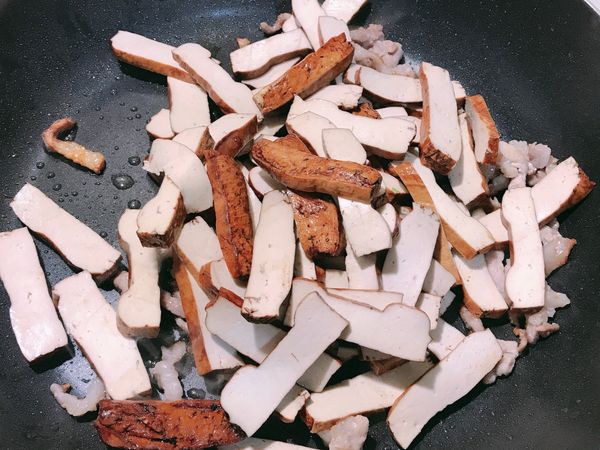 先下豆乾，加一匙鹽先調味，然後炒至微焦