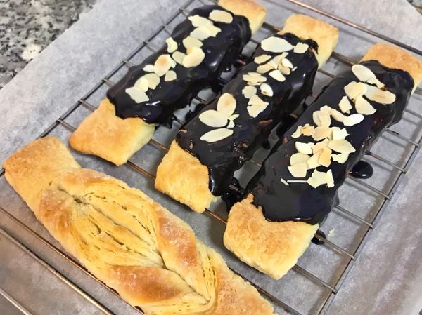 將巧克力醬淋在派司上，再撒上杏仁片；