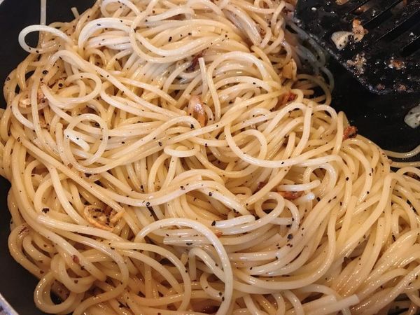 麵這時候應該差不多煮好了，把它撈出來放進平底鍋裡，並加一些些煮麵水進來~ (做這些動作前可以先將平底鍋拿離開火爐，因為我們鍋裡的橄欖油很多，讓鍋子稍微降一點溫度，這樣比較不會噴濺，比較安全)
接著再撒上比平時稍微多一些的黑胡椒來調味，試吃一下，如果味道不夠的話就再加一點點的鹽巴