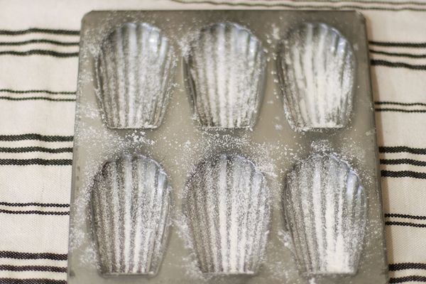 將烤模塗上奶油並過篩撒上麵粉，這樣後續脫模比較容易