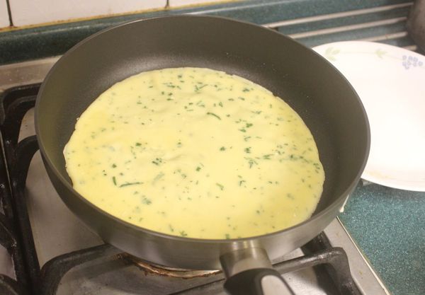 先將一面煎好。可以用鍋鏟或手指捏著邊緣察看，若已經出現一些焦色就可以翻面。