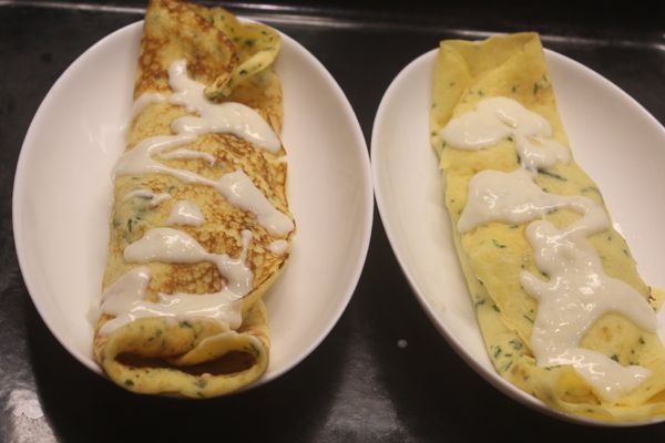 將餅皮兩邊捲好，淋上一些白醬。
