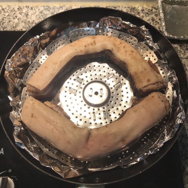 將醃好的鹹豬肉沖洗一下,除去表面的鹽、胡椒粒和花椒，擺放在煙燻的架子上；