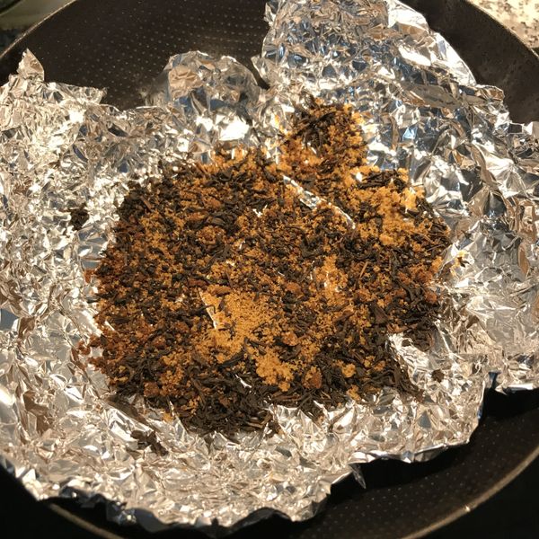鍋裡鋪上鋁箔紙，亮面朝上，撒入茶葉與糖，放上架子；