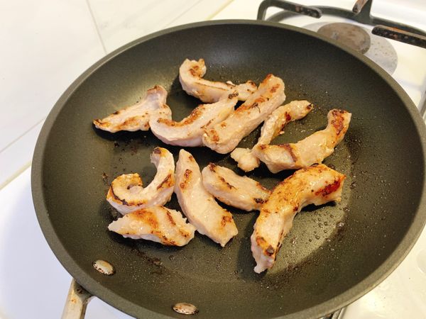 將豬肉下鍋，中小火，以1大匙白酒將其煎至焦黃。