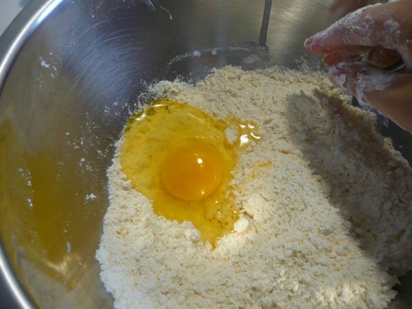 將粉類材料糖、鹽、速發酵母加入麵粉內拌勻,加入蛋拌勻