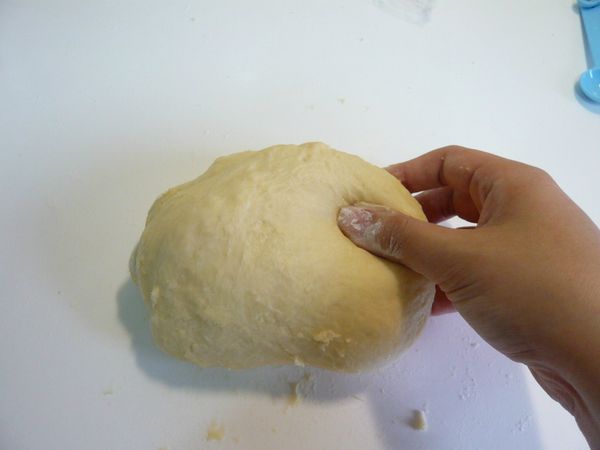 用刮板集中麵團，抓取麵糰