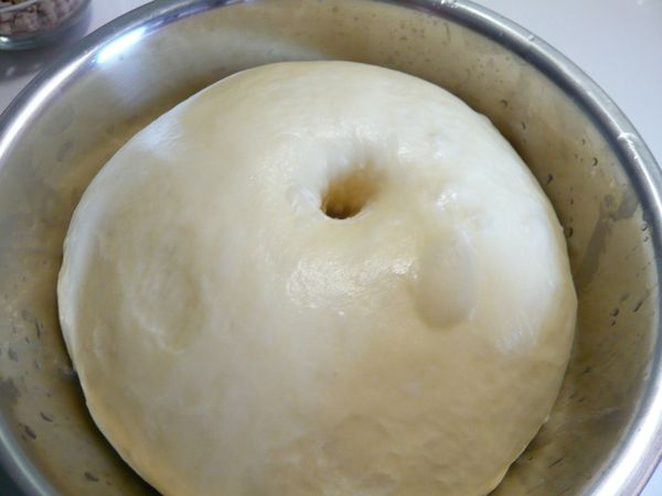 將麵團滾圓放入工作盆內,灑上少許的水蓋上保鮮膜放入烤箱內發酵50分發酵至2倍大,天冷可在烤箱內放杯熱水幫助發酵