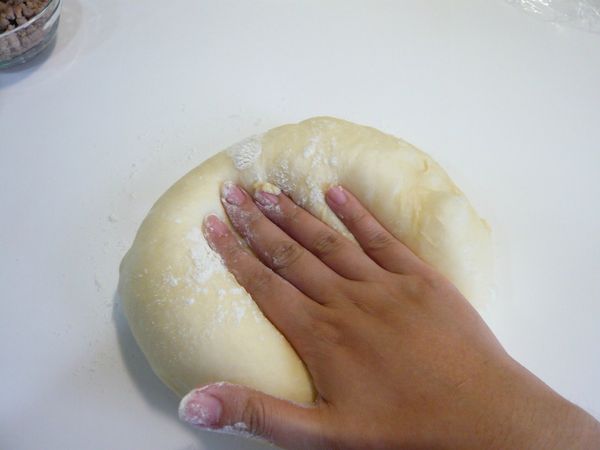 將發酵至2倍大的麵糰移出，桌上撒上高筋麵粉將麵團空氣拍出