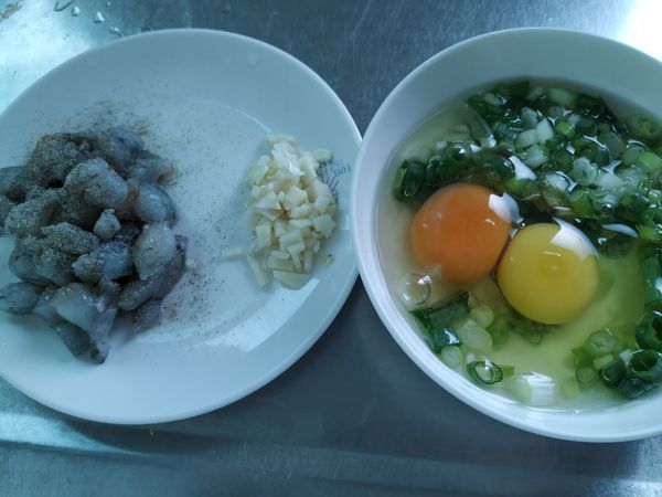 蝦仁切丁，撒點胡椒鹽抓醃一下，蒜頭切成蒜末，蔥切成蔥花，雞蛋打入碗中，加入蔥花高湯和少許胡椒鹽，打散