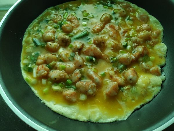 鍋子擦乾淨，再加點油，然後倒入混合了蝦丁的蛋液，轉動一下鍋子，讓蛋液鋪平