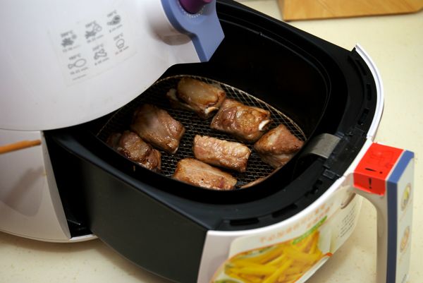 於5分鐘左右時，抽出炸籃，翻動小排，並查看上色狀況。（若喜歡外表更酥的話，可以在時間到後，將溫度提高至200度，再炸3分鐘，讓外表更酥，也可達到再逼油的效果，但需注意避免太焦。）