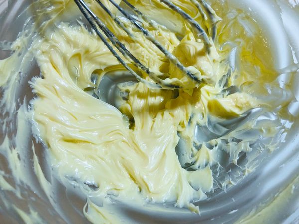 常溫奶油打到發白，加入糖粉、奶粉續打