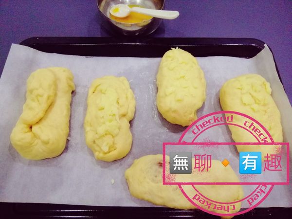 之前備用的蛋黃派上用場了。
把麵包表面刷上一層蛋液，這會讓你的麵包烤出來後成色更美。
然後依自己喜好放上起司在麵包上。

在這之前，可以先開烤箱預熱200度