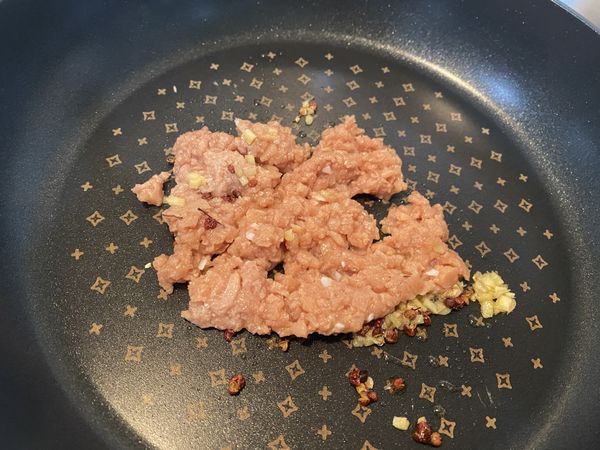 起鍋爆香花椒粒、薑末、新豬肉