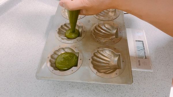 模具塗上一層奶油，麵糊擠入模具內，約8分滿。