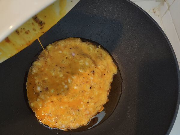 把混和好的薑黃雞蛋，倒進已燒熱的鍋中煎