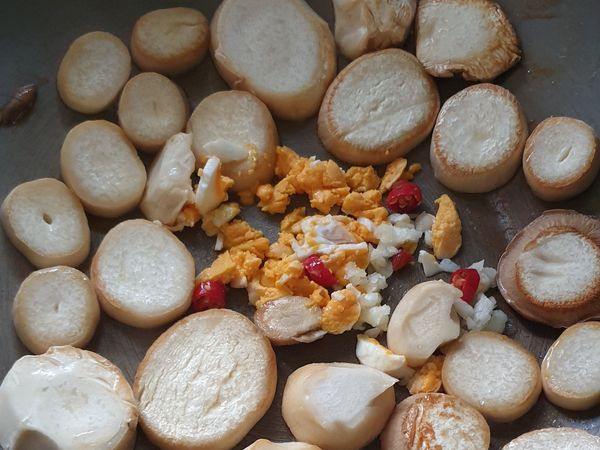 中間騰出空間，下油，放入辣椒蒜頭鹹蛋黃爆香