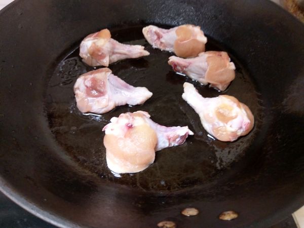 先熱鍋，再倒入少許沙拉油後將醃好的雞小腿放入鍋中煎至兩面呈金黃色。