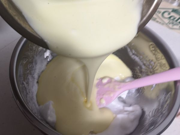 然后将拌匀的面糊倒入蛋白霜里，用折拌方式拌匀。