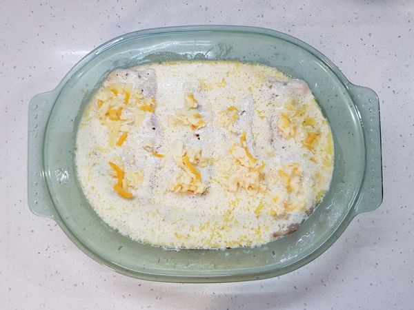 先在鯛魚排上撒焗烤起司絲、麵包粉。