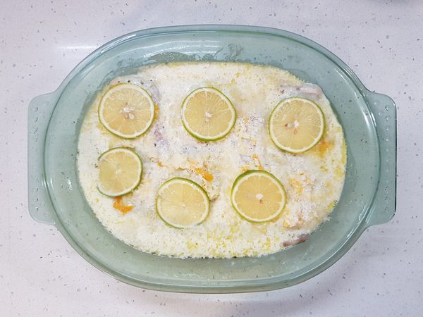 將檸檬片蓋在鯛魚排上。