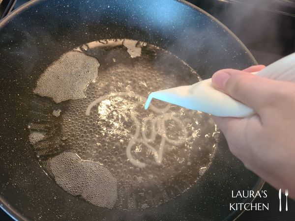 煮一鍋沸水，將麵糊擠進滾水中