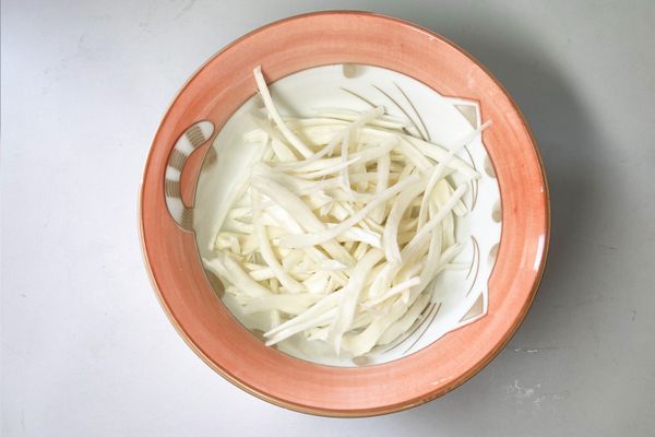 白菇的頭尾去掉，留中段後用手撕碎模仿螃蟹肉絲，滾水燙過。