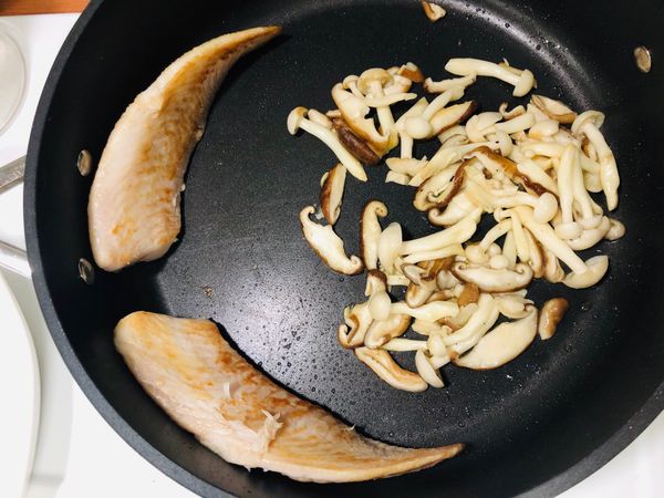 當另一面也變色時，將魚立起靠在鍋緣，中間魚肉部份還未熟！菇菇加半匙鹽翻炒後起鍋。